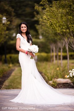 Stunning Indian bride posing on her white wedding dress. Stunning Indian bride posing on her white wedding dress.