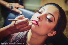 Indian bride being assisted by makeup artist Indian bride being assisted by makeup artist