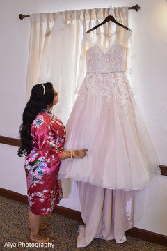Indian bride admiring her white wedding dress. Indian bride admiring her white wedding dress.