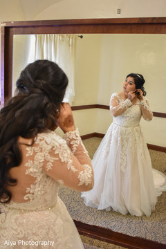 Indian bride putting her earrings on. Indian bride putting her earrings on.