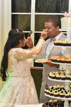 Sweet Indian couple cutting their wedding cake. Sweet Indian couple cutting their wedding cake.