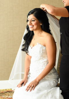 Enchanting Indian bride putting her white veil. Enchanting Indian bride putting her white veil.