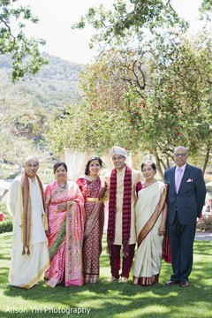 Indian bride and groom posing with family guests Indian bride and groom posing with family guests