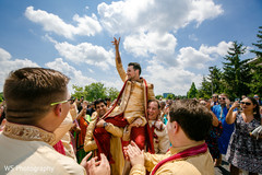 Indian groom being lifted up during pre-wedding celebrations Indian groom being lifted up during pre-wedding celebrations