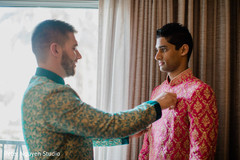 Indian groom putting his sherwani on. Indian groom putting his sherwani on.