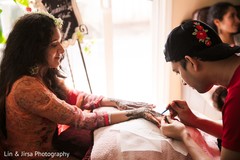 Bride being assisted with Mehndi Bride being assisted with Mehndi