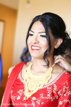 Indian bride getting her polki necklace on. Indian bride getting her polki necklace on.