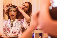 Indian bride putting her matha patti on. Indian bride putting her matha patti on.