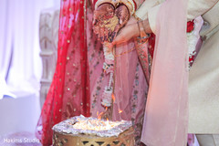 Indian couple pouring rice to sacred fire. Indian couple pouring rice to sacred fire.