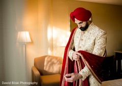 Indian groom putting his sehra on. Indian groom putting his sehra on.
