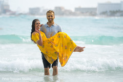 Indian couple at the beach taking off the turmeric paste. Indian couple at the beach taking off the turmeric paste.