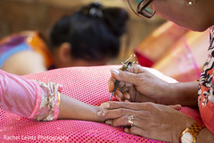 Indian bride being assisted by mehndi artist Indian bride being assisted by mehndi artist
