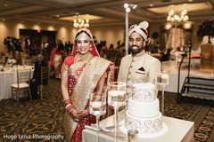 Indian bride and groom about to cut the cake Indian bride and groom about to cut the cake
