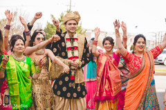Indian groom with bridesmaids walking at his baraat procession. Indian groom with bridesmaids walking at his baraat procession.