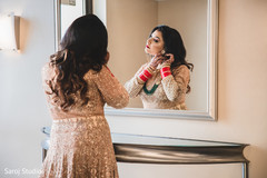 Indian bride putting her reception earrings. Indian bride putting her reception earrings.
