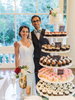 Lovely capture Indian bride and groom next to cake capture. Lovely capture Indian bride and groom next to cake capture.