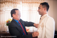 Indian groom being assisted by family guest Indian groom being assisted by family guest