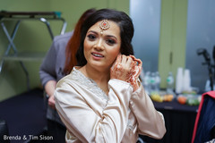 Indian bride putting her earings on. Indian bride putting her earings on.