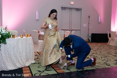 Indian groom taking bride's shoes at reception capture. Indian groom taking bride's shoes at reception capture.