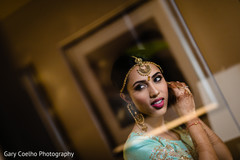 Indian bride putting her earings on. Indian bride putting her earings on.