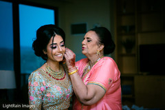 Sweet Indian bride's mother helping her to get ready Sweet Indian bride's mother helping her to get ready