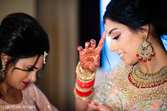 Indian bride being helped by bridesmaid Indian bride being helped by bridesmaid