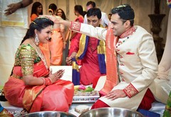 Indian groom putting rice to bride's head. Indian groom putting rice to bride's head.