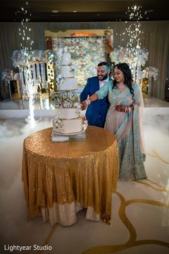 Sweet Indian couple cutting their wedding cake. Sweet Indian couple cutting their wedding cake.