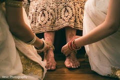 Indian bride getting help to put her anklets on. Indian bride getting help to put her anklets on.