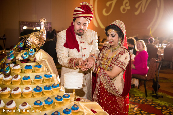 Indian bride and groom cutting the cake