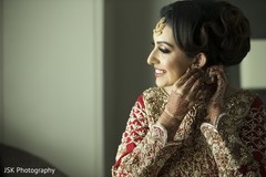 Indian bride putting earrings on Indian bride putting earrings on