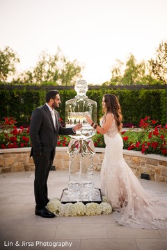 Indian couple having a toast next to an ice sculpture. Indian couple having a toast next to an ice sculpture.