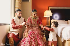 Lovely Indian bride being helped to put her kalire on. Lovely Indian bride being helped to put her kalire on.