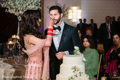 Indian bride giving the groom a taste of wedding cake. Indian bride giving the groom a taste of wedding cake.