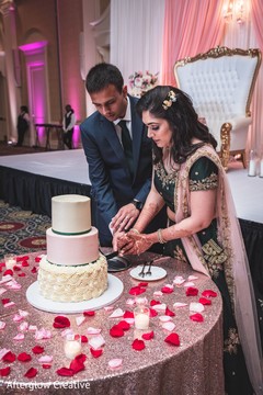 Lovely capture Indian bride and groom cutting cake together. Lovely capture Indian bride and groom cutting cake together.