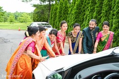 Indian bridesmaids with groomsmen holding vehicle. Indian bridesmaids with groomsmen holding vehicle.