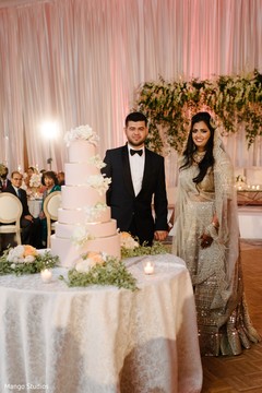 Lovely capture Indian bride and groom cutting cake together. Lovely capture Indian bride and groom cutting cake together.