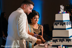Indian couple cutting the wedding cake. Indian couple cutting the wedding cake.