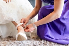 Closeup capture of Indian bride putting her white wedding shoes. Closeup capture of Indian bride putting her white wedding shoes.