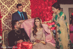Indian bride being covered in her gown. Indian bride being covered in her gown.