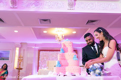 Indian couple cutting the wedding cake. Indian couple cutting the wedding cake.