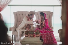 Indian groom putting ceremonial red thread on maharani's wrist. Indian groom putting ceremonial red thread on maharani's wrist.