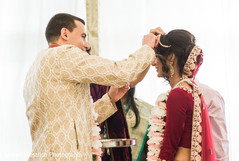 Enchanting Indian groom puts red mark on maharani's forehead. Enchanting Indian groom puts red mark on maharani's forehead.