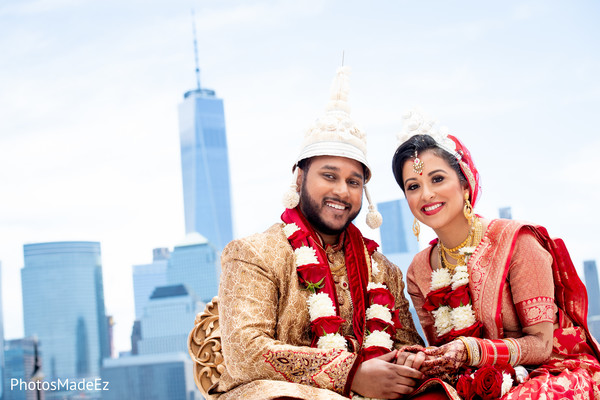 Indian couple posing with their ceremony crowns.
