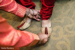 Indian groom being assisted to put his elegant shoes on. Indian groom being assisted to put his elegant shoes on.