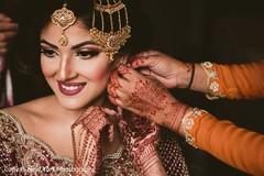 Indian bride getting her earrings on. Indian bride getting her earrings on.