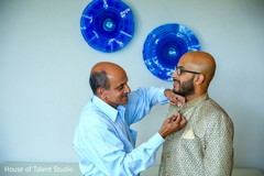Indian broom being helped to put his sherwani on. Indian broom being helped to put his sherwani on.