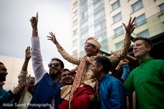 Indian groom being lifted up during pre-wedding celebrations Indian groom being lifted up during pre-wedding celebrations