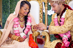 Indian groom putting wedding ring on bride Indian groom putting wedding ring on bride