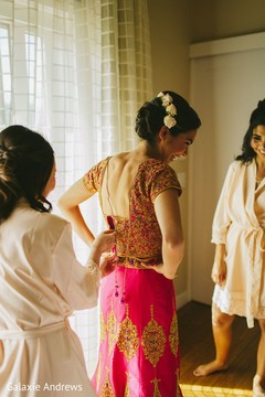 Indian bride getting her lehengas blouse on. Indian bride getting her lehengas blouse on.